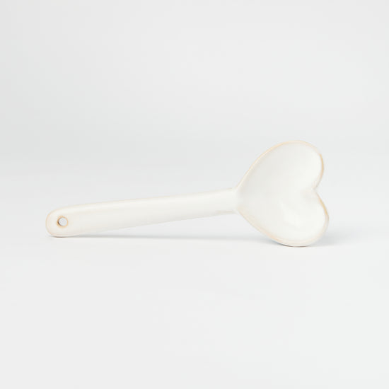 Small white ceramic spoon with a heart shaped scooper