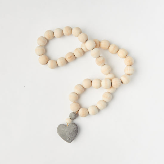 A string of chunky wooden beads with a heart pendant