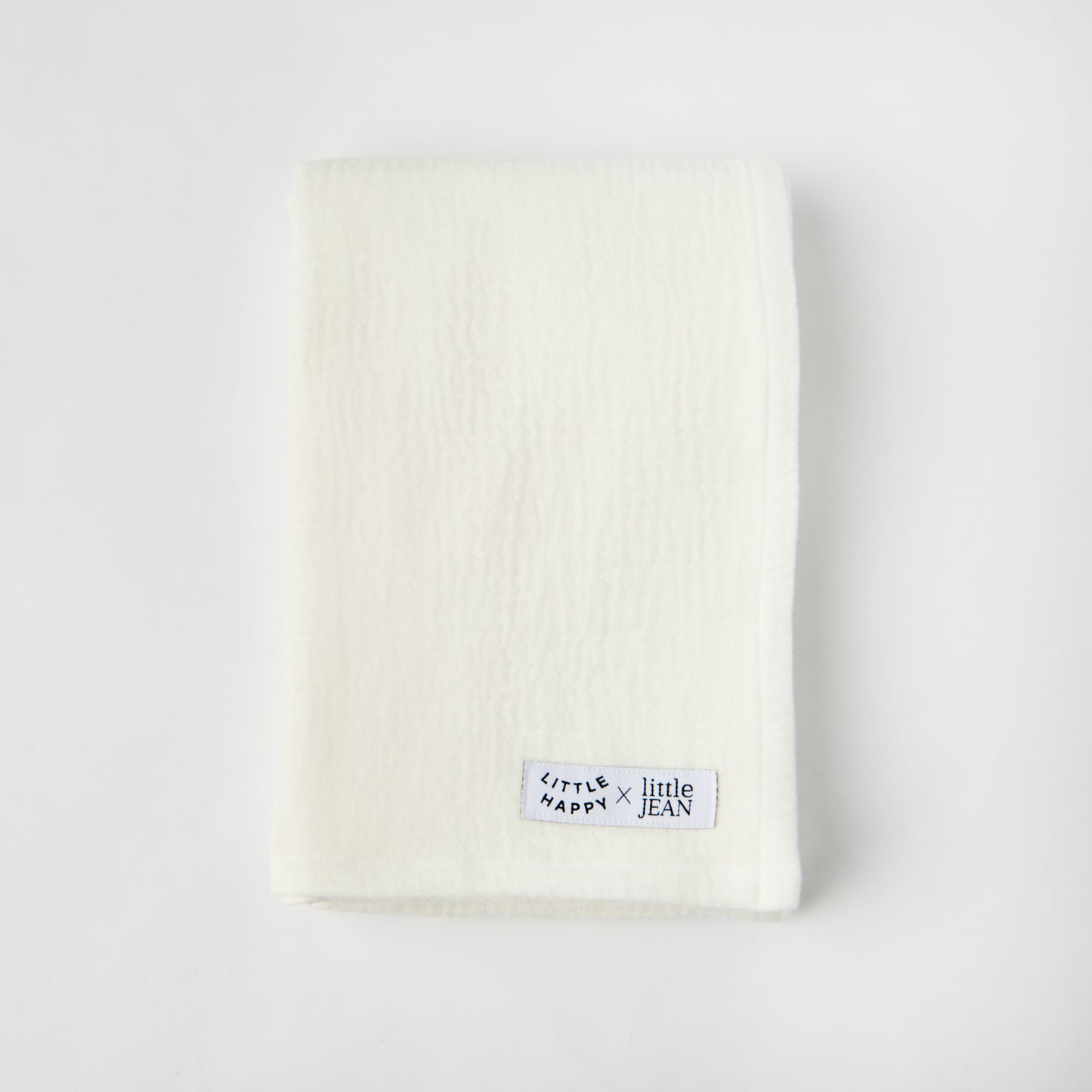 Cream swaddle blanket with small logo patch